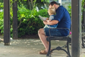 Man reading to his daughter 