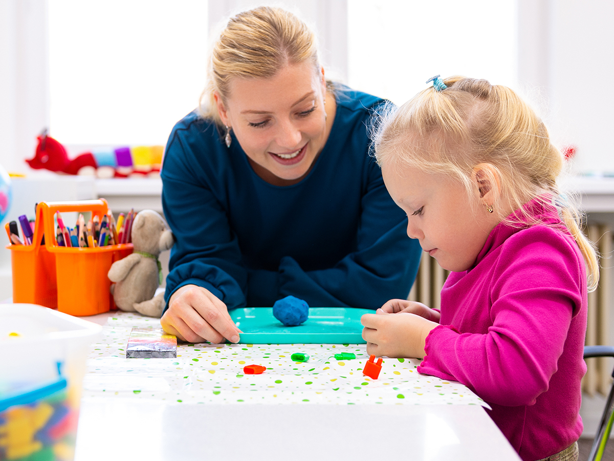 Teacher facilitating sensory play with preschooler