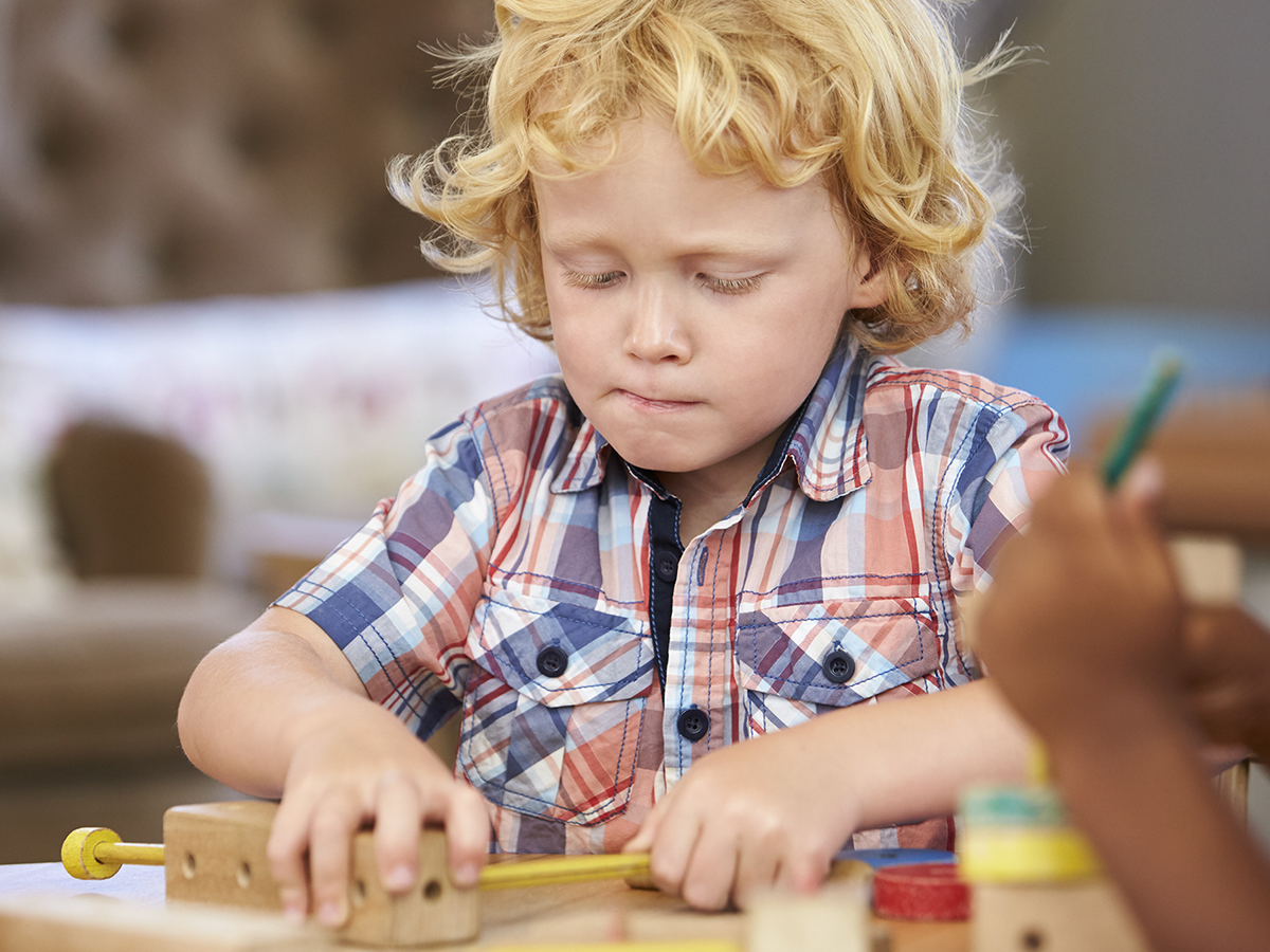 Preschool boy playing with building block toys