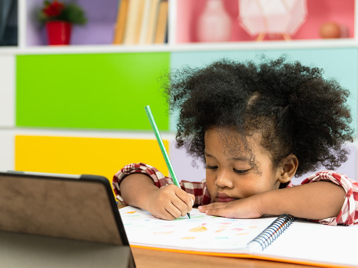 Preschool girl writing in workbook