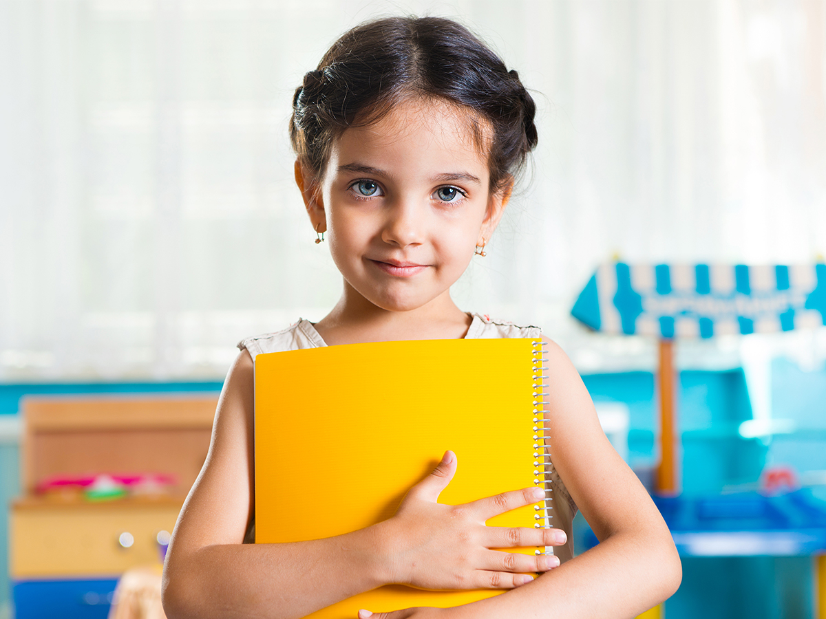 Preschool girl holding notebook