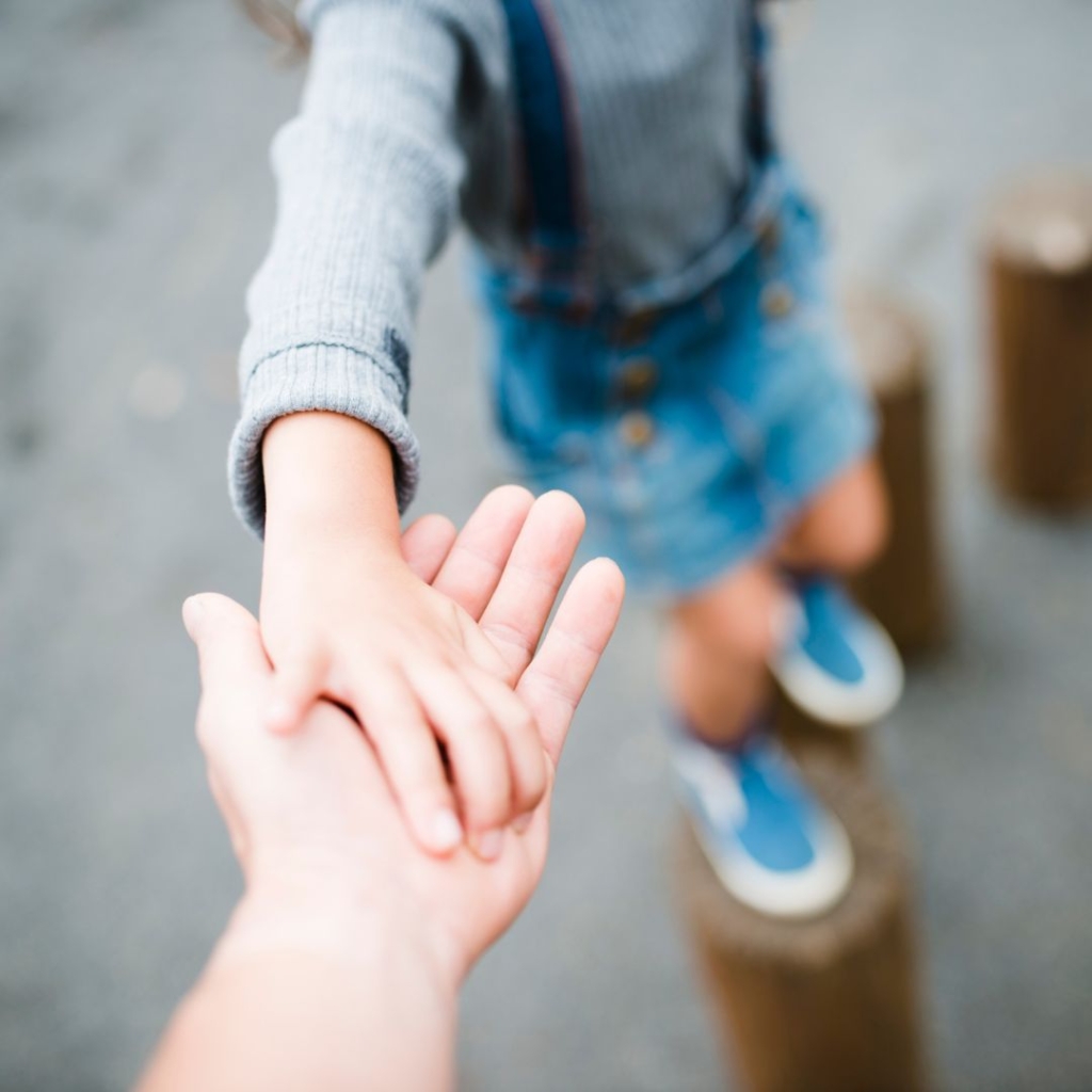 A parent's hand outstretched to help their child