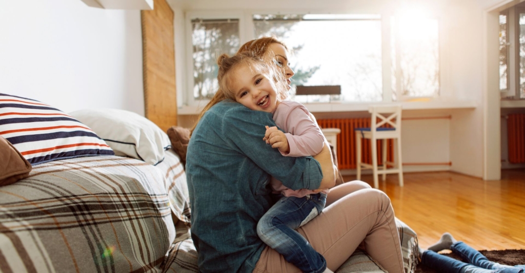A mother hugging her young daughter