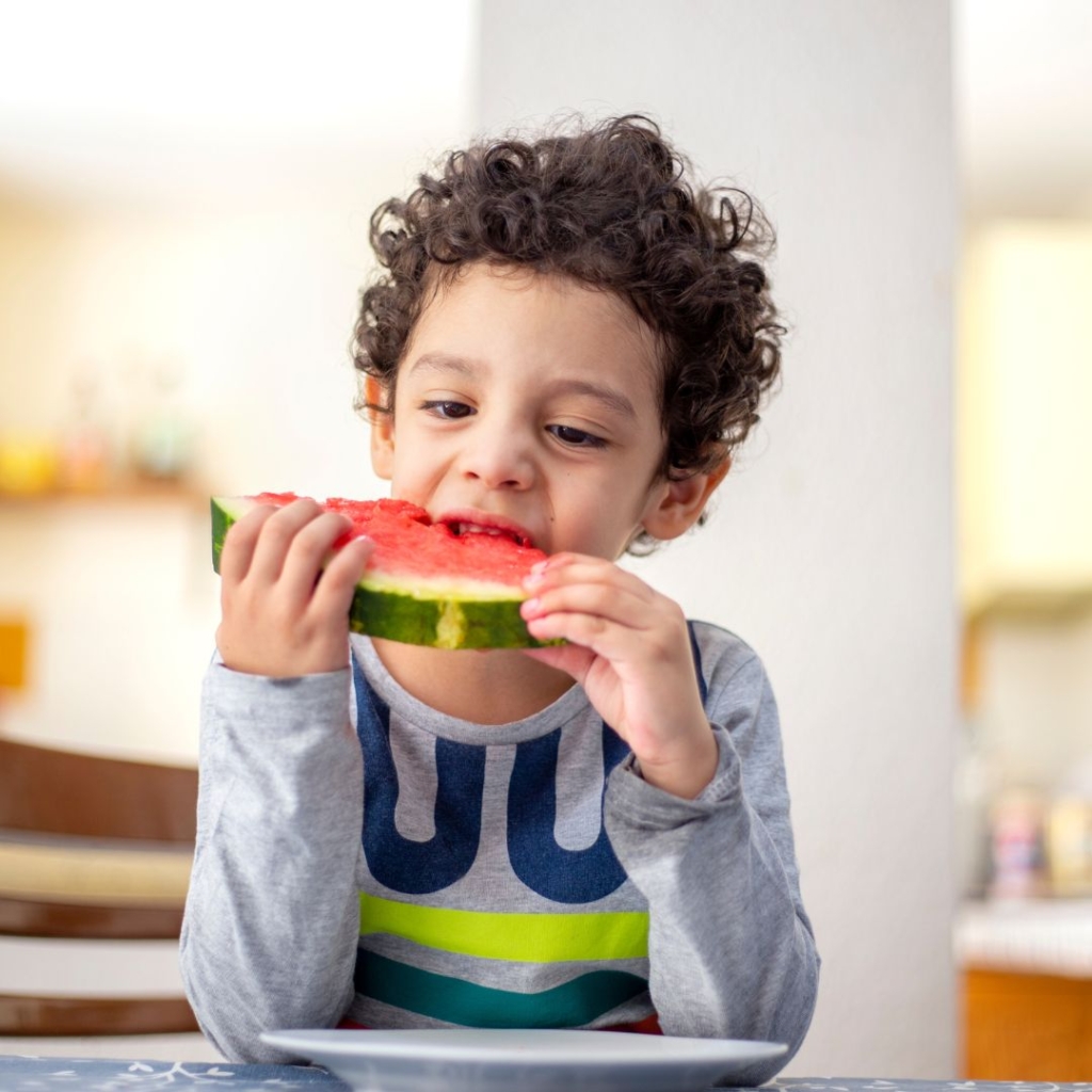 Little boy eating watermelon
