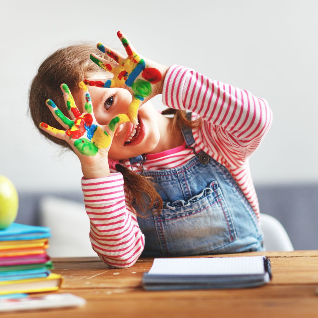 preschooler showing off painted-covered hands