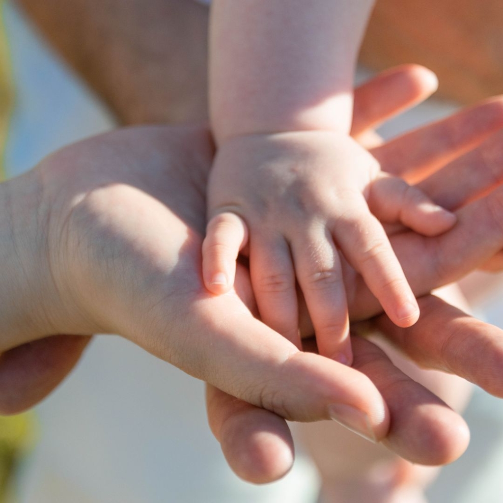 A mother holding a child's hand.