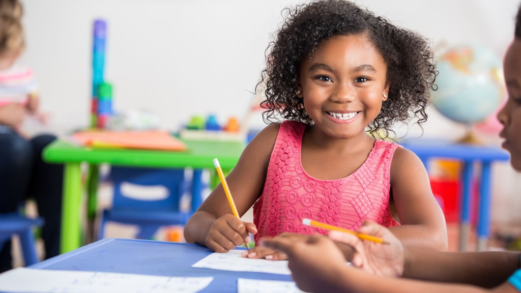 smiling kid holding pencil