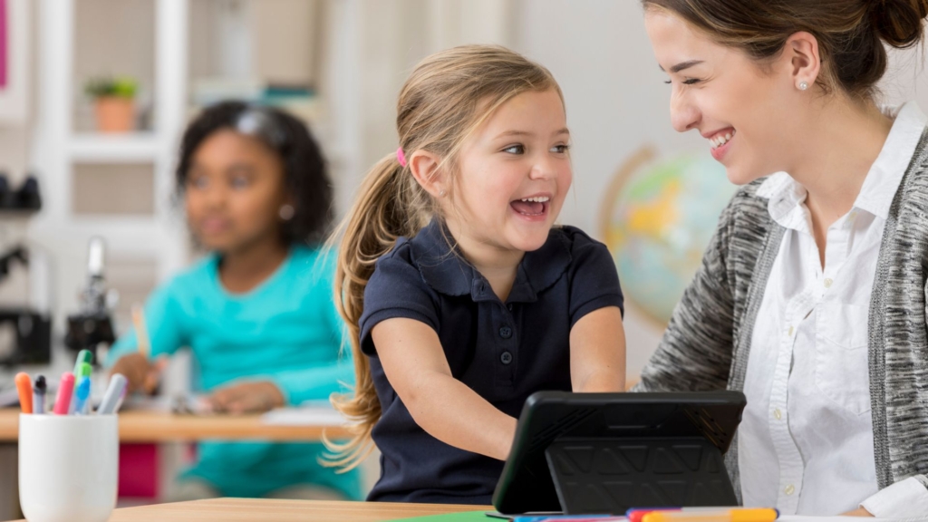 Preschool instructor with child and tablet