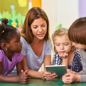 preschoolers with teacher and tablet