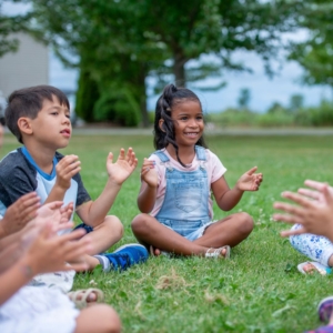 kids sitting in the grass playing a game