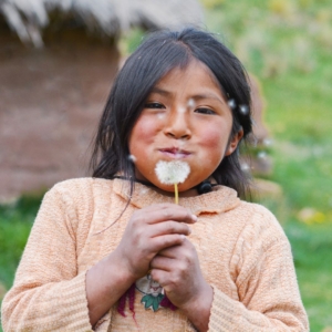 girl blowing dandelion seeds