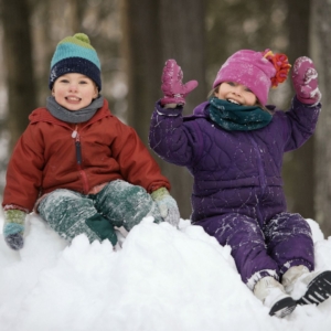 kids sitting on a snow bank
