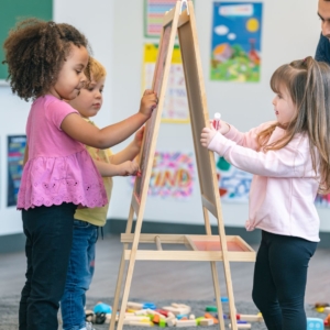 preschoolers drawing on easels