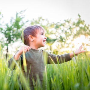 a kid smiling in tall grass