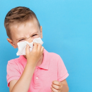 Young boy blowing his nose